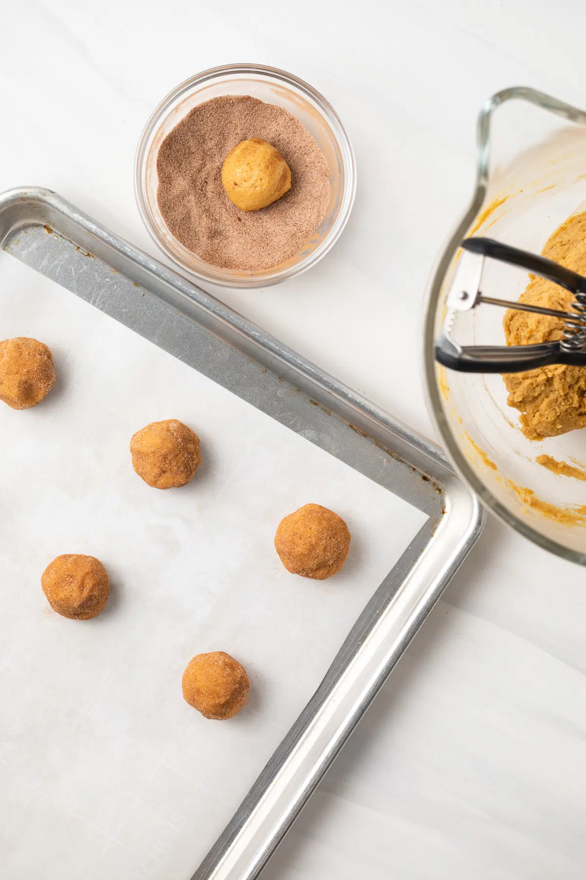 Pumpkin snickerdoodle dough balls rolled into cinnamon sugar.