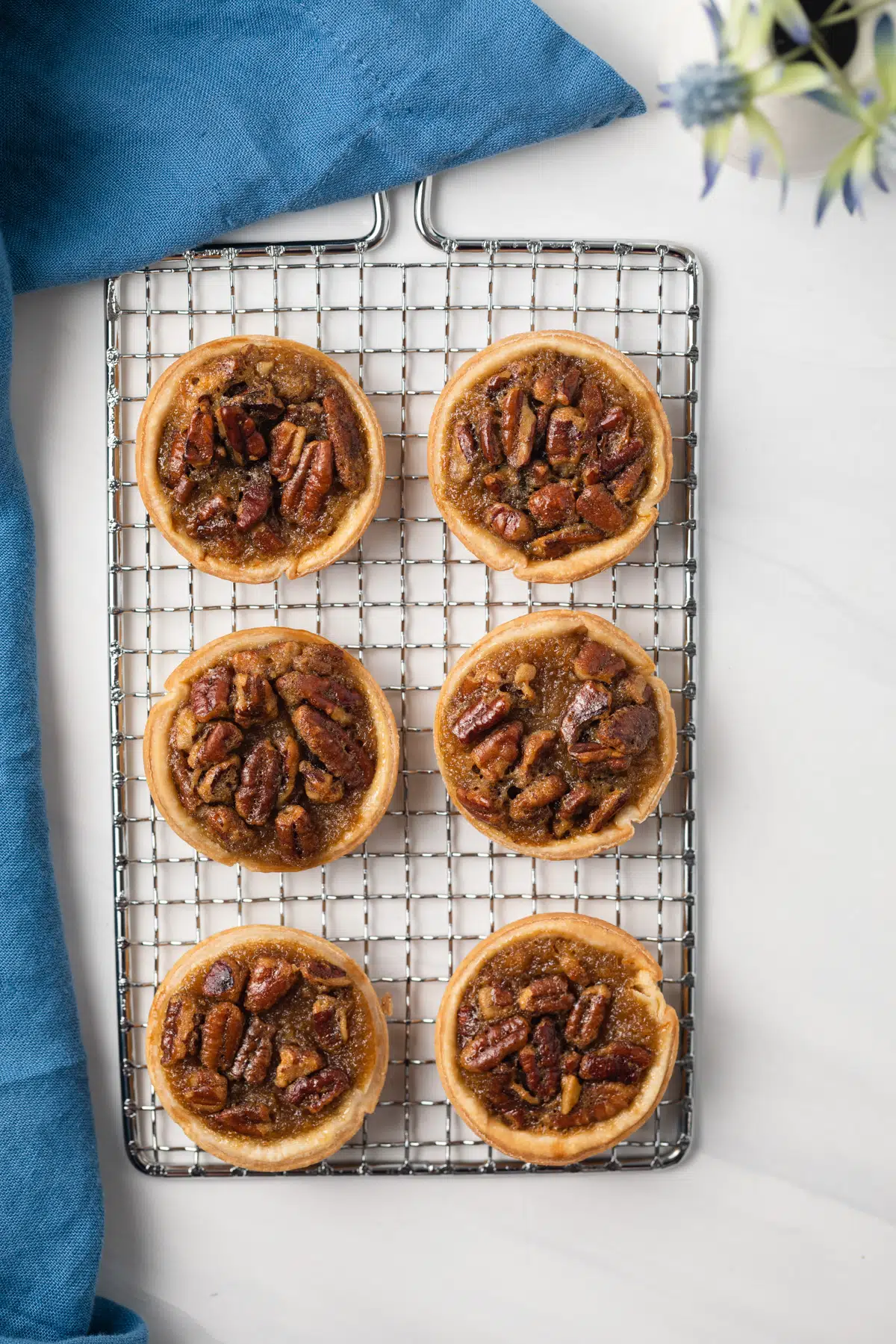 Mini pecan pies on a cooling rack.