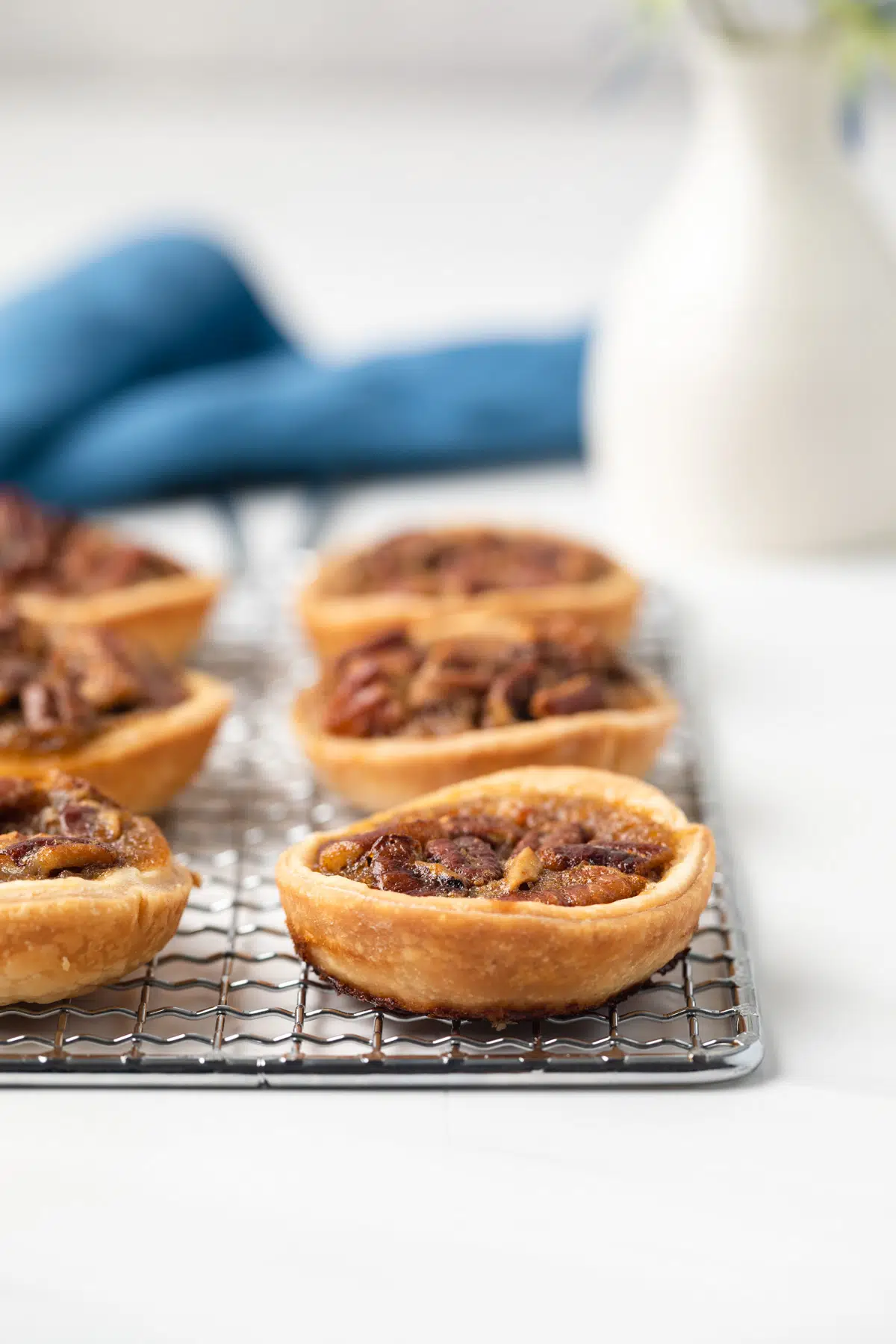 Side view of mini pecan pies on a wire rack.