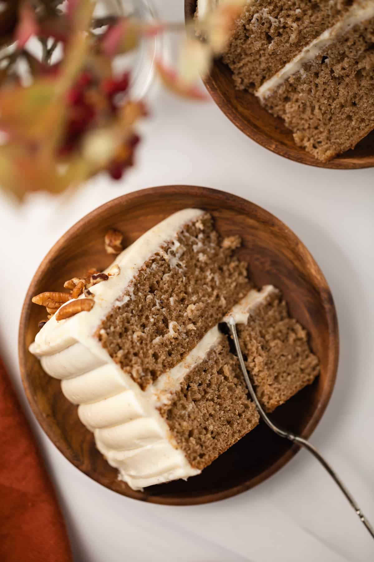 Slice of spice cake on brown plate with fork.