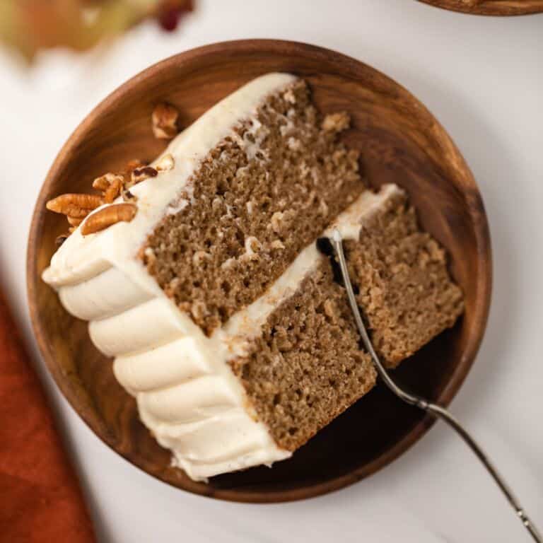 Slice of spice cake on brown plate with fork.