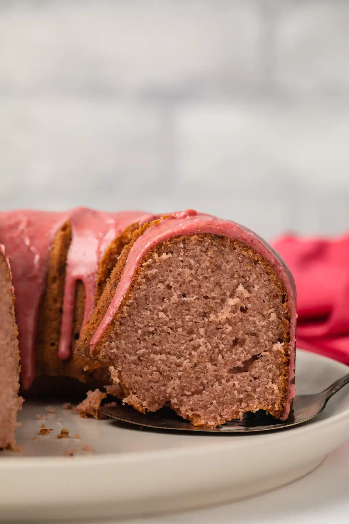 Slice of strawberry pound cake being taken out.