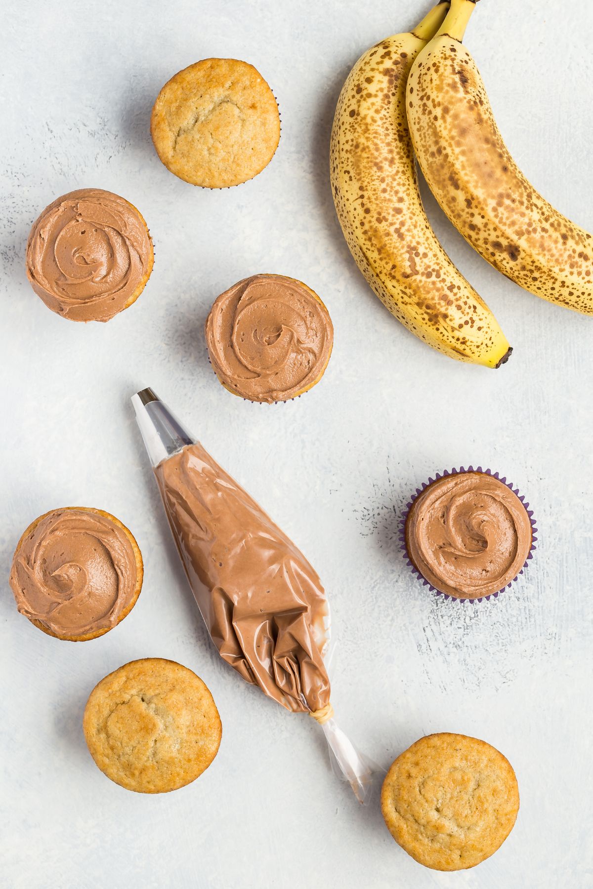 Overhead of banana cupcakes with Nutella frosting.