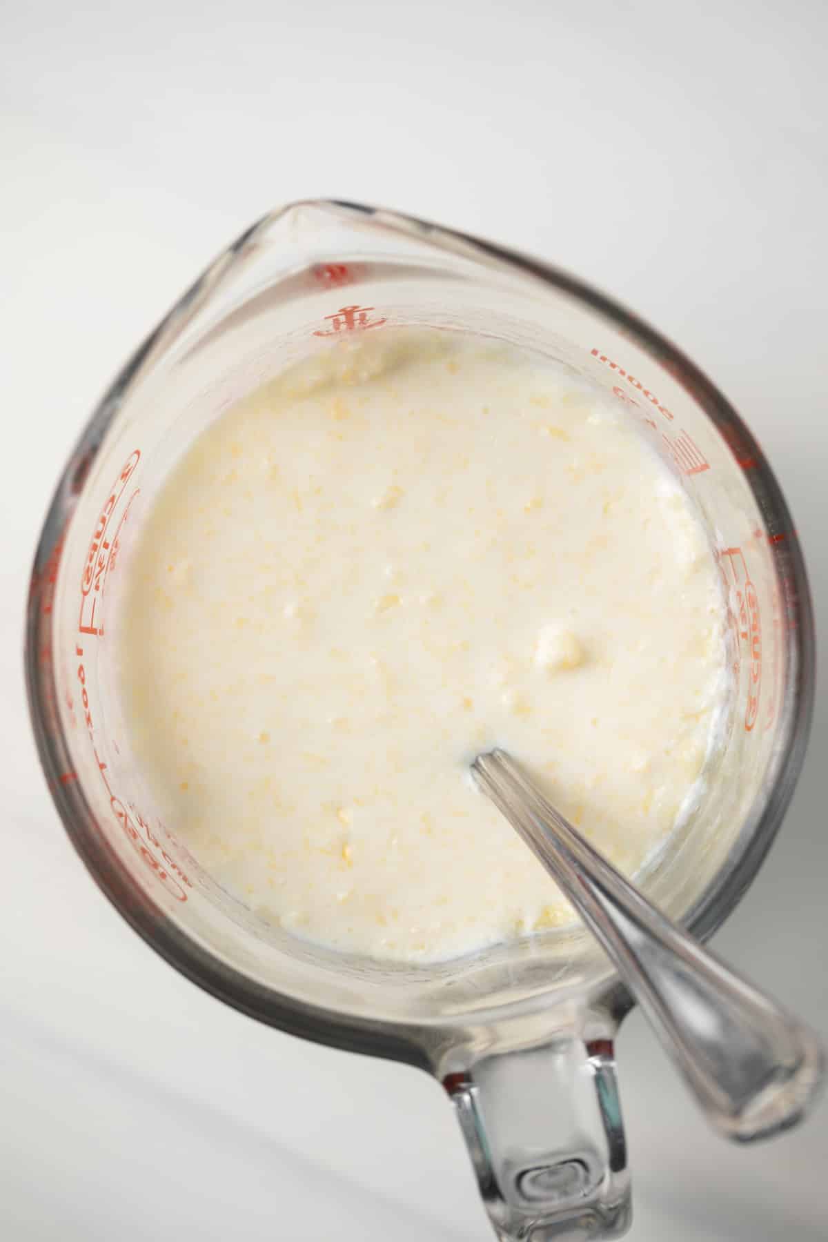 Buttermilk and butter mixed in measuring cup.