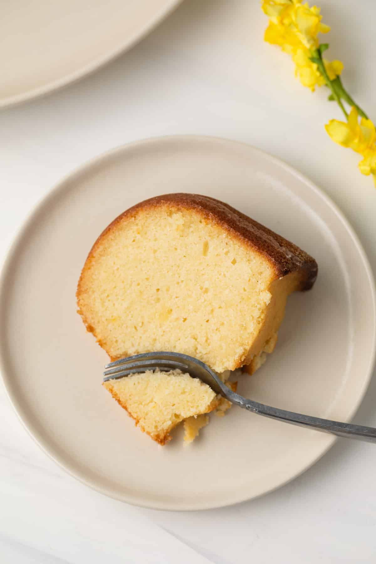 Slice of lemon pound cake with fork taking a bite out.