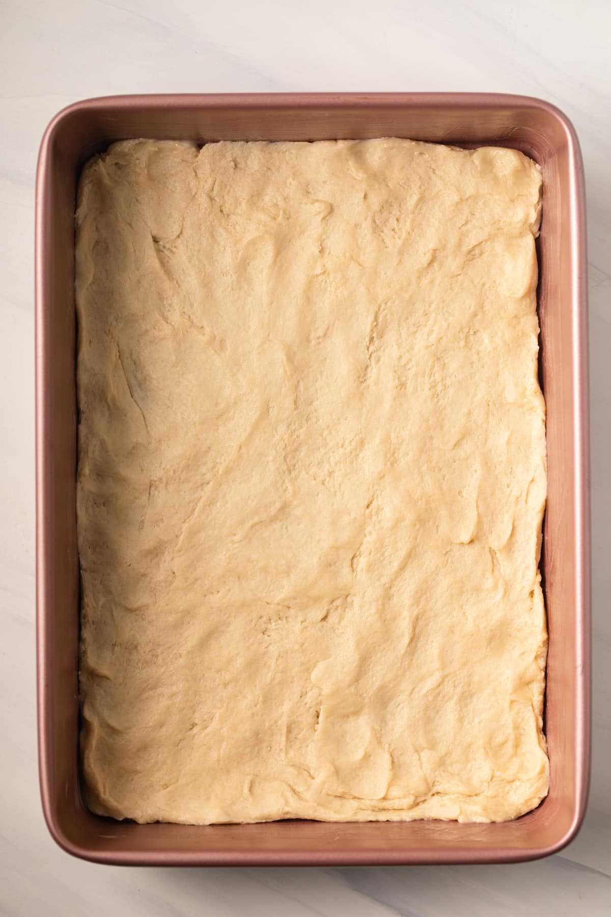 Yeasted cake base in baking pan.