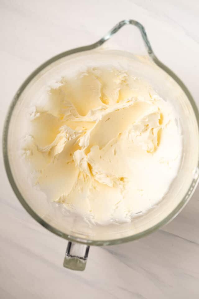 Creamed butter and cream cheese in glass bowl.