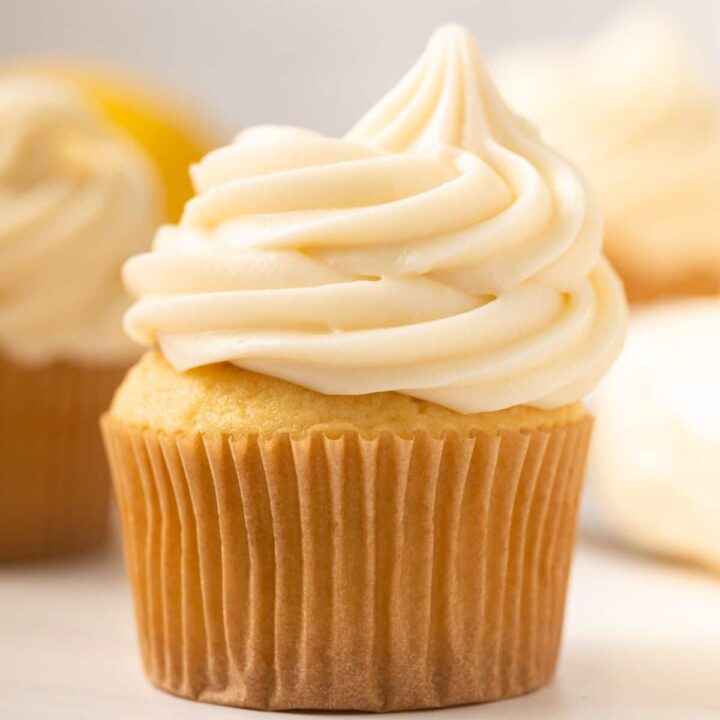 Close up of lemon cream cheese frosting swirled in top of a cupcake.