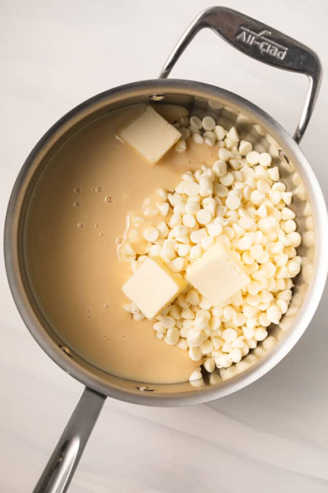 White chocolate chips, butter, and sweetened condensed milk in saucepan.