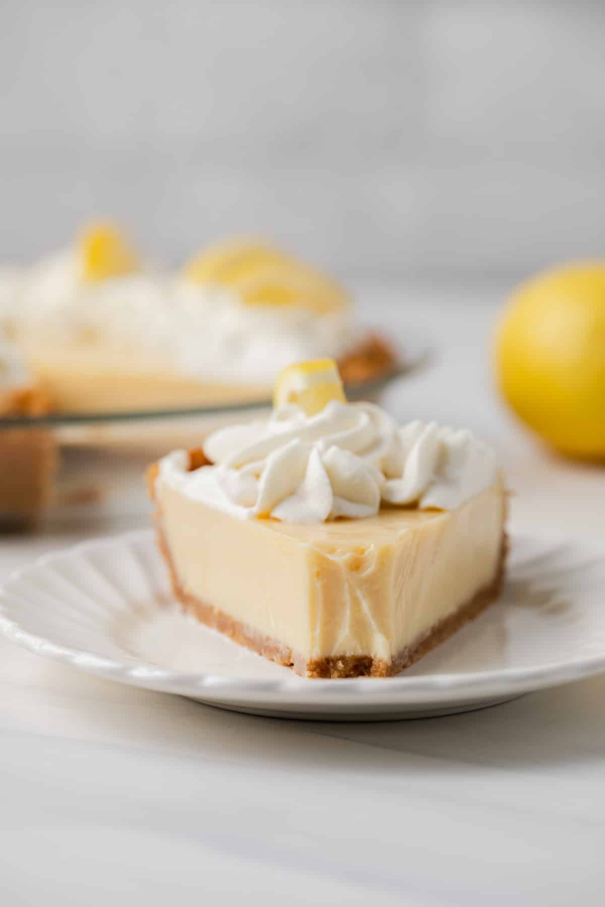 Slice of lemon pie with bite taken out.