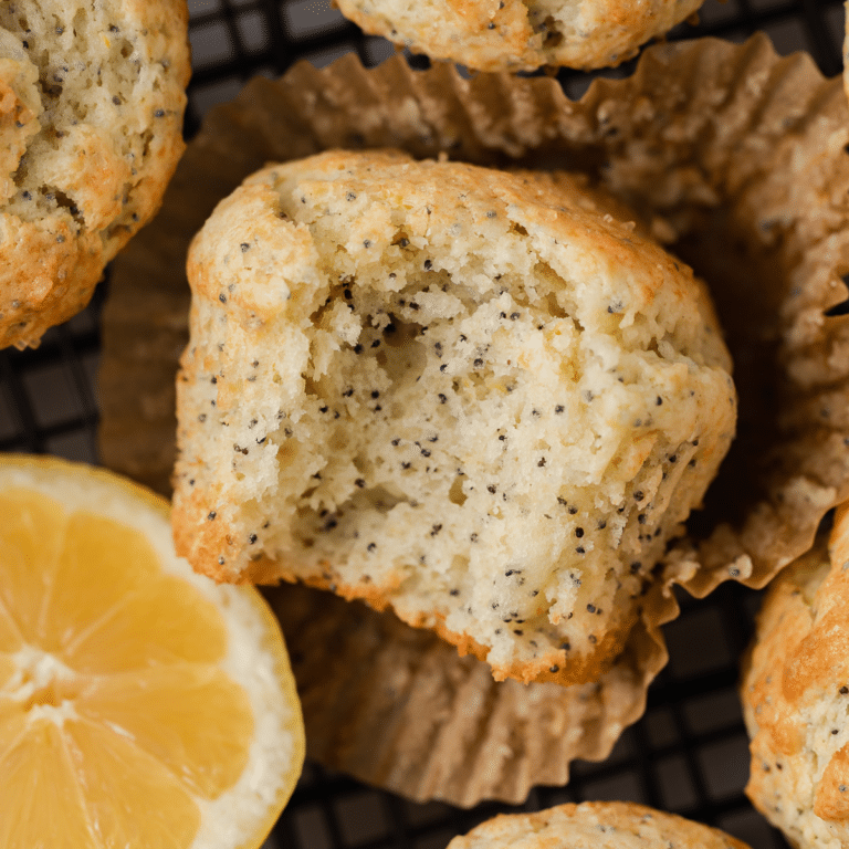 Close up of lemon poppy seed muffin with bite taken out.