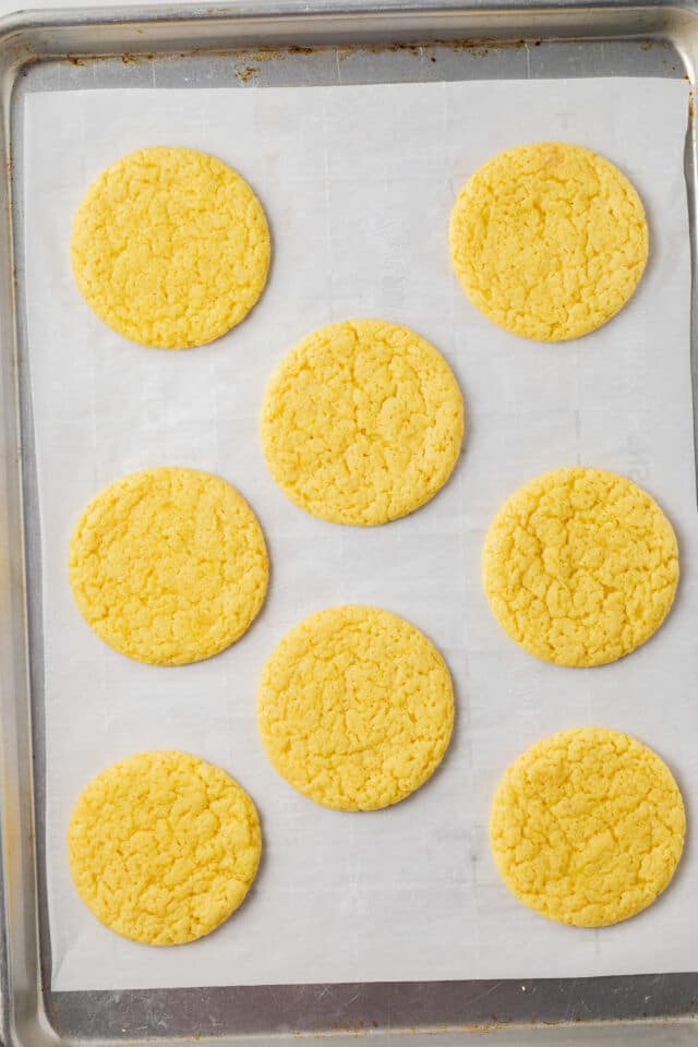 Baked lemon cookies on baking sheet.