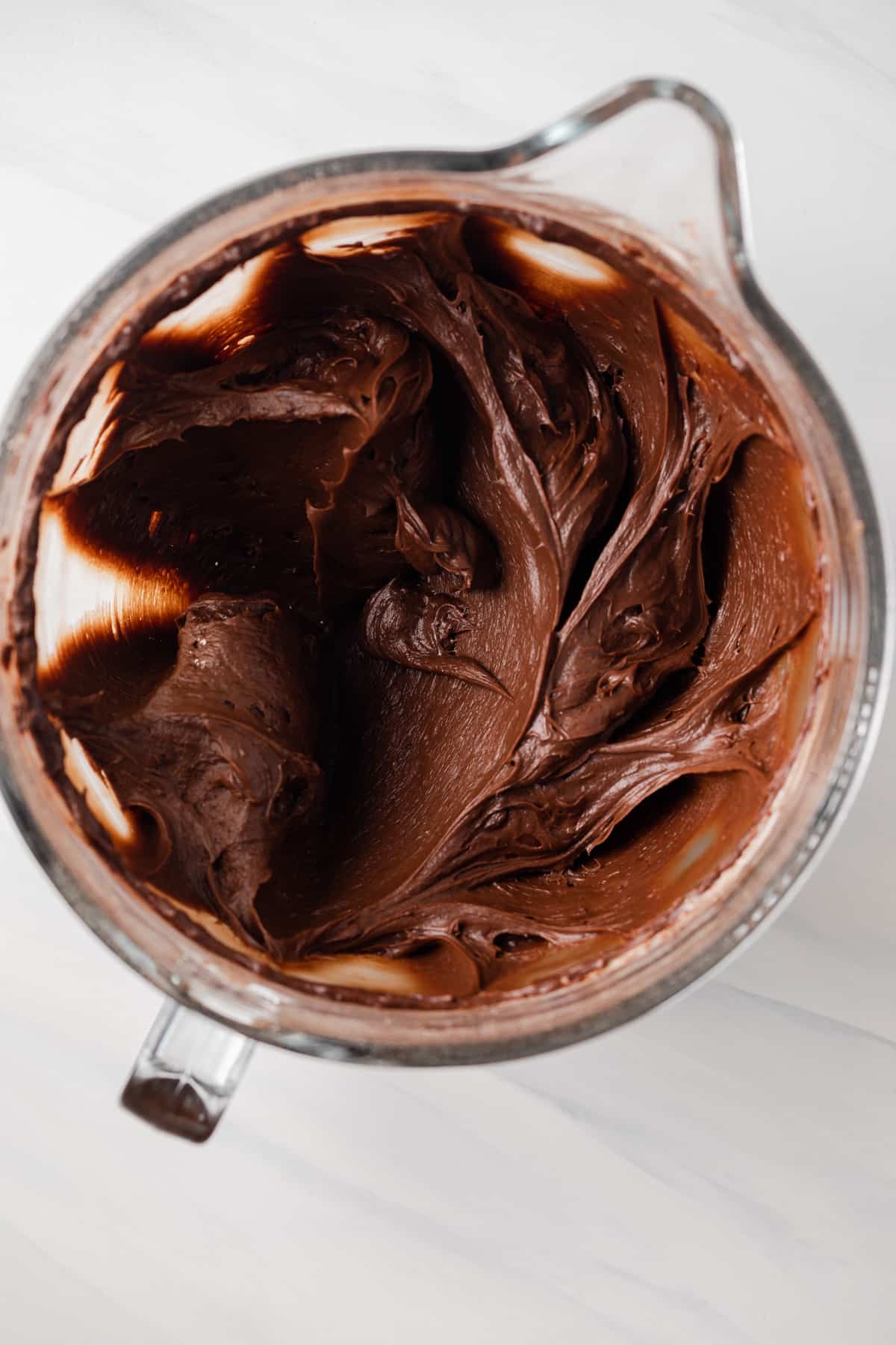 Chocolate fudge frosting in glass bowl.