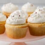 Close up of almond cupcakes on a pink cake stand.