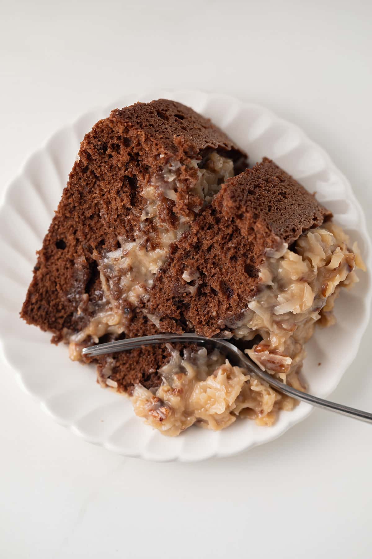 Slice of German chocolate cake with fork taking out a bite.