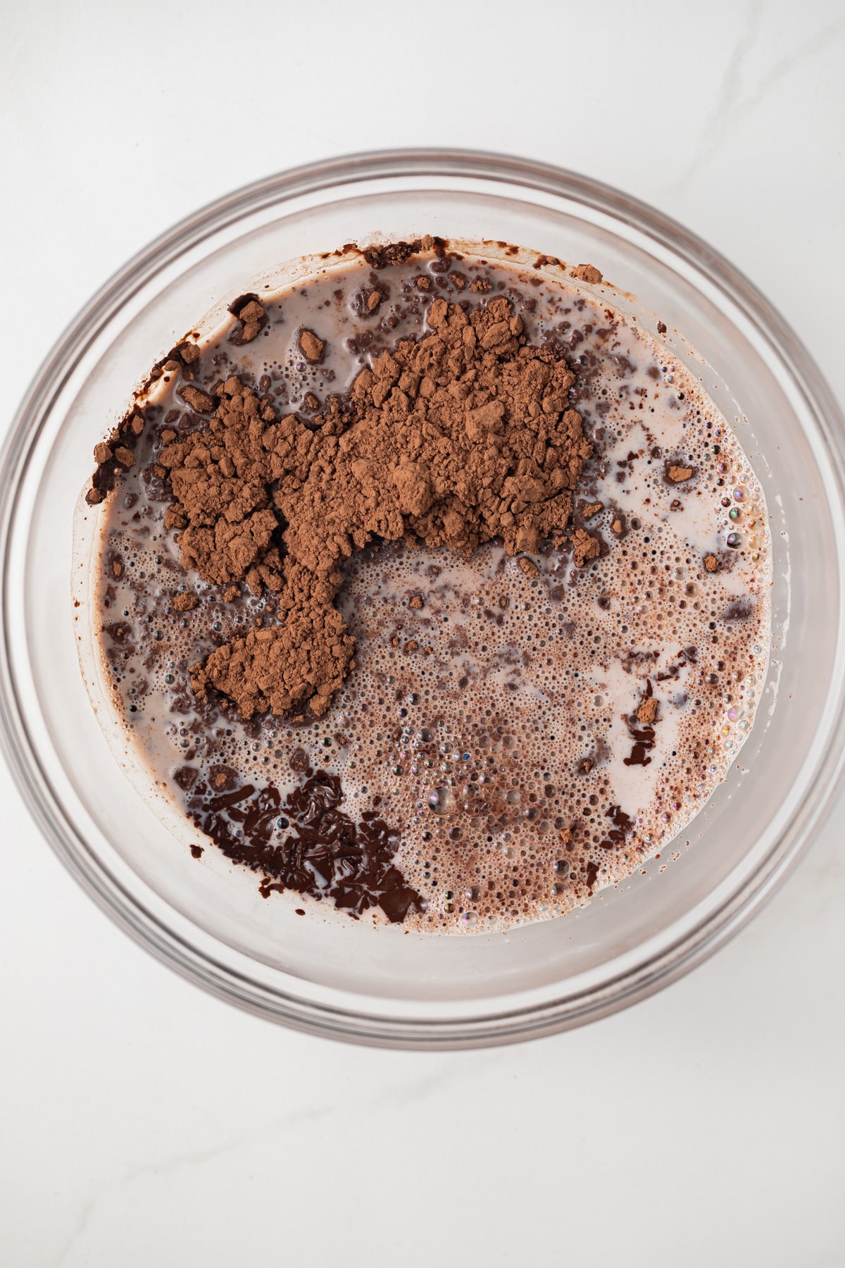 Chocolate, cocoa powder, and cream in glass bowl.