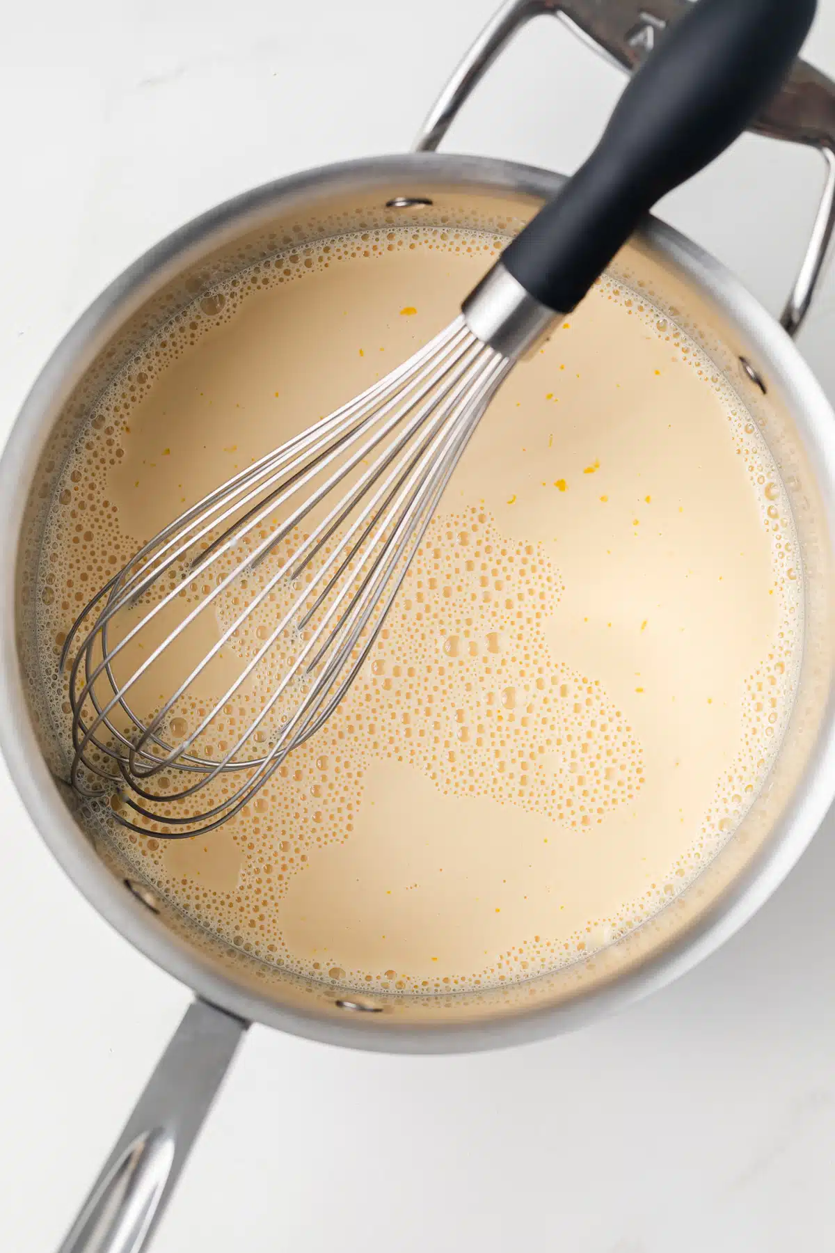 Egg yolks and evaporated milk whisked in sauce pan.