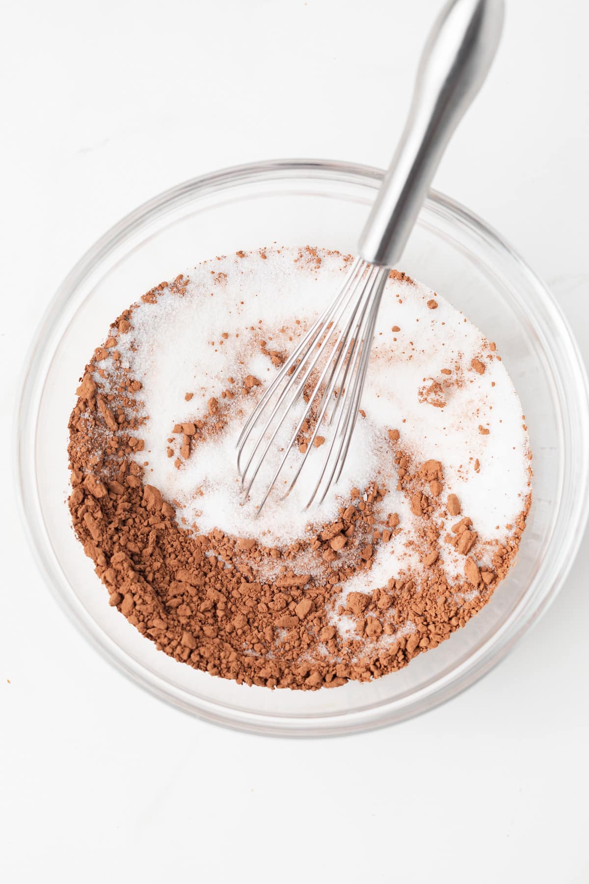 Sugar and cocoa powder in glass bowl.