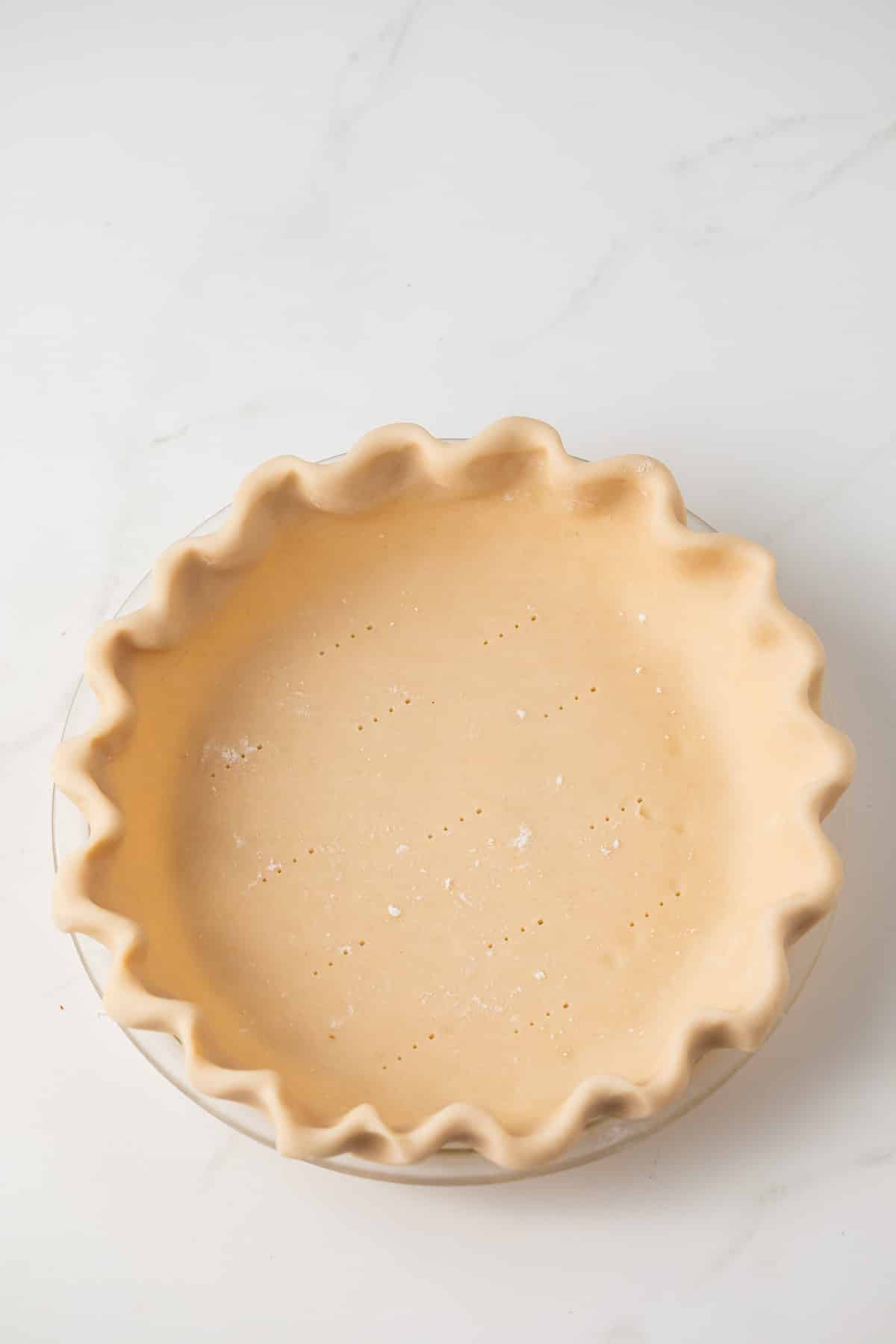 Unbaked pie shell in glass pie dish.