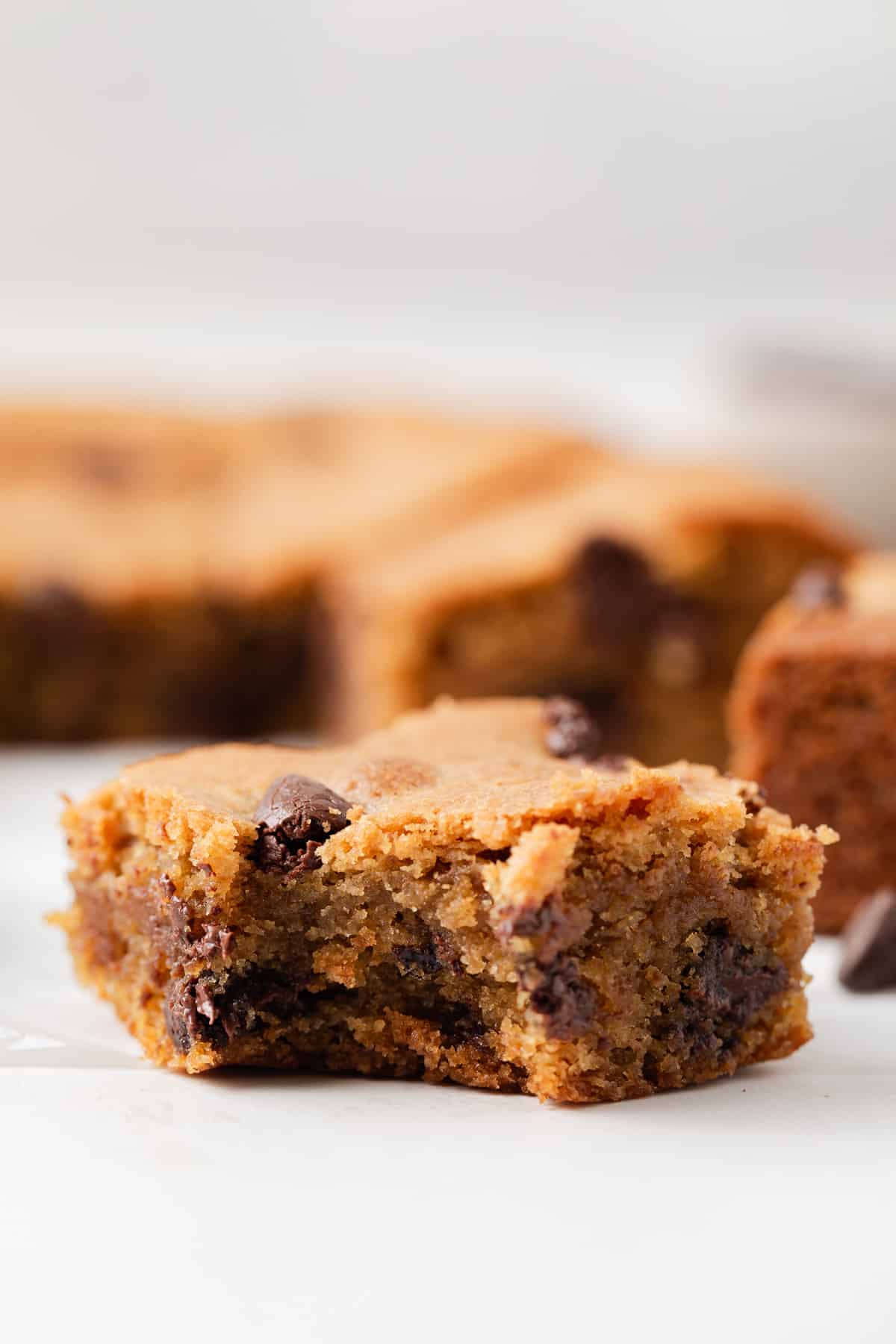Peanut butter chocolate chip blondie with a bite taken out.