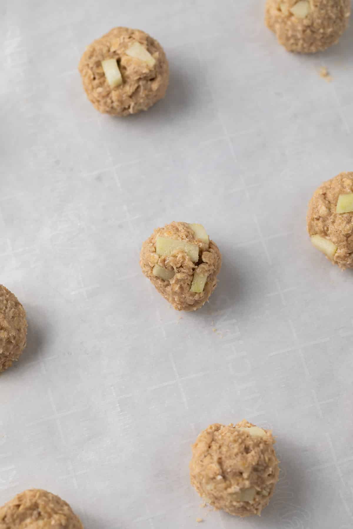 Unbaked apple oatmeal cookies on a baking sheet.