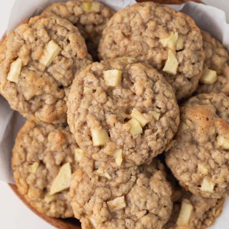 Apple oatmeal cookies on a serving platter with parchment paper.