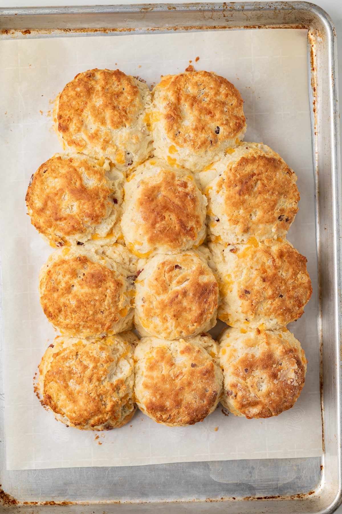 Baked bacon cheddar biscuits on a baking sheet.