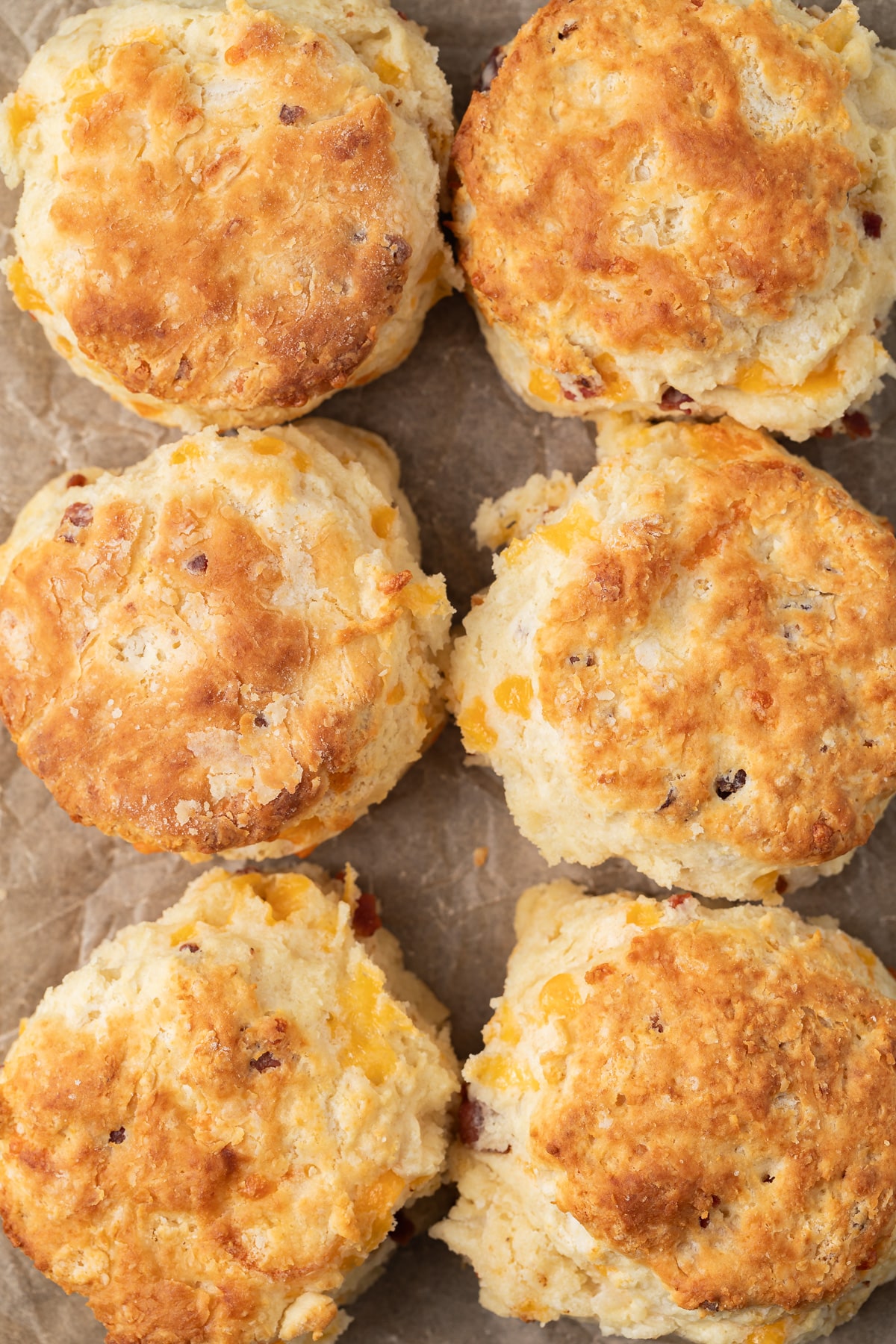 Bacon cheddar biscuits on parchment paper.