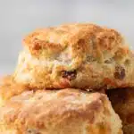 Close up of bacon cheddar biscuits stacked on a plate.