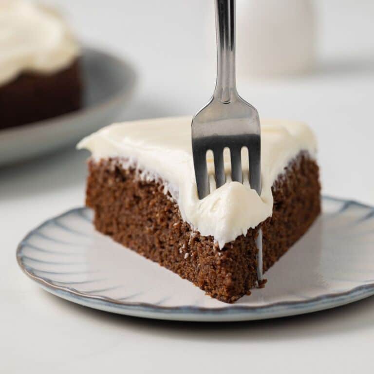 Slice of gingerbread cake with a fork taking a bite out.