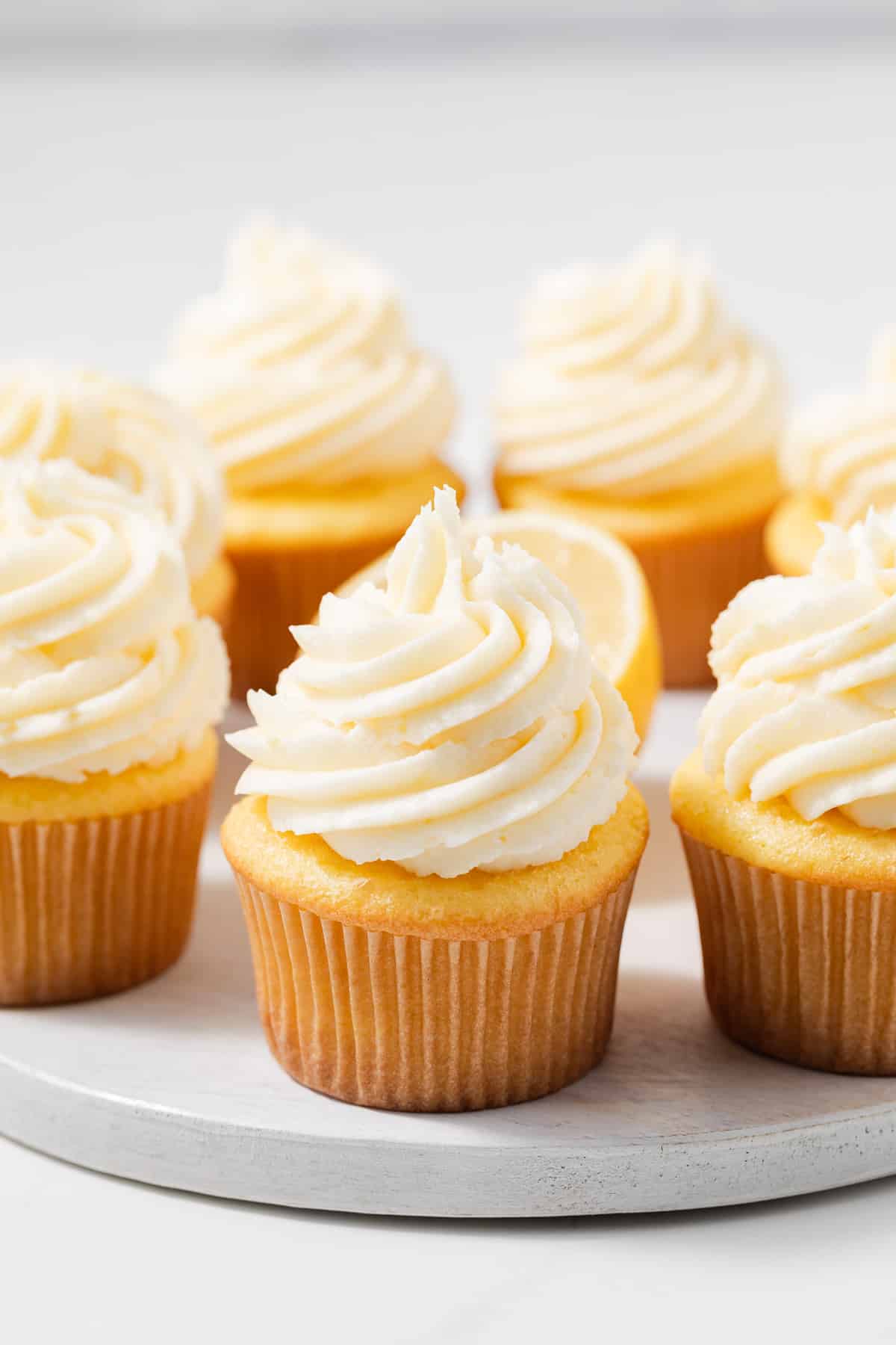 Side view of cupcakes topped with lemon buttercream frosting.