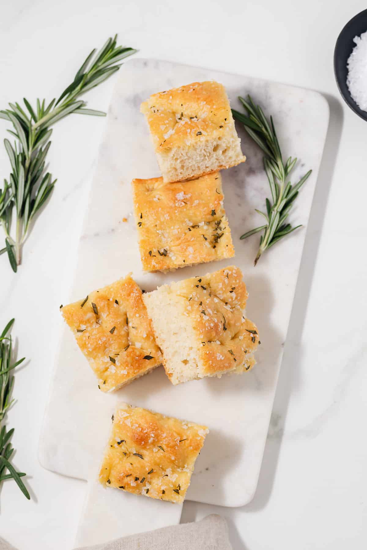 Five slices of focaccia on marble serving platter.