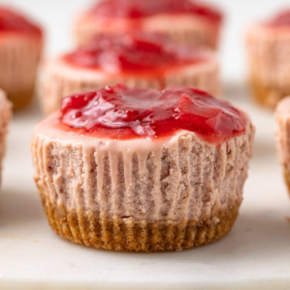 Close up of mini strawberry cheesecake with strawberry topping.