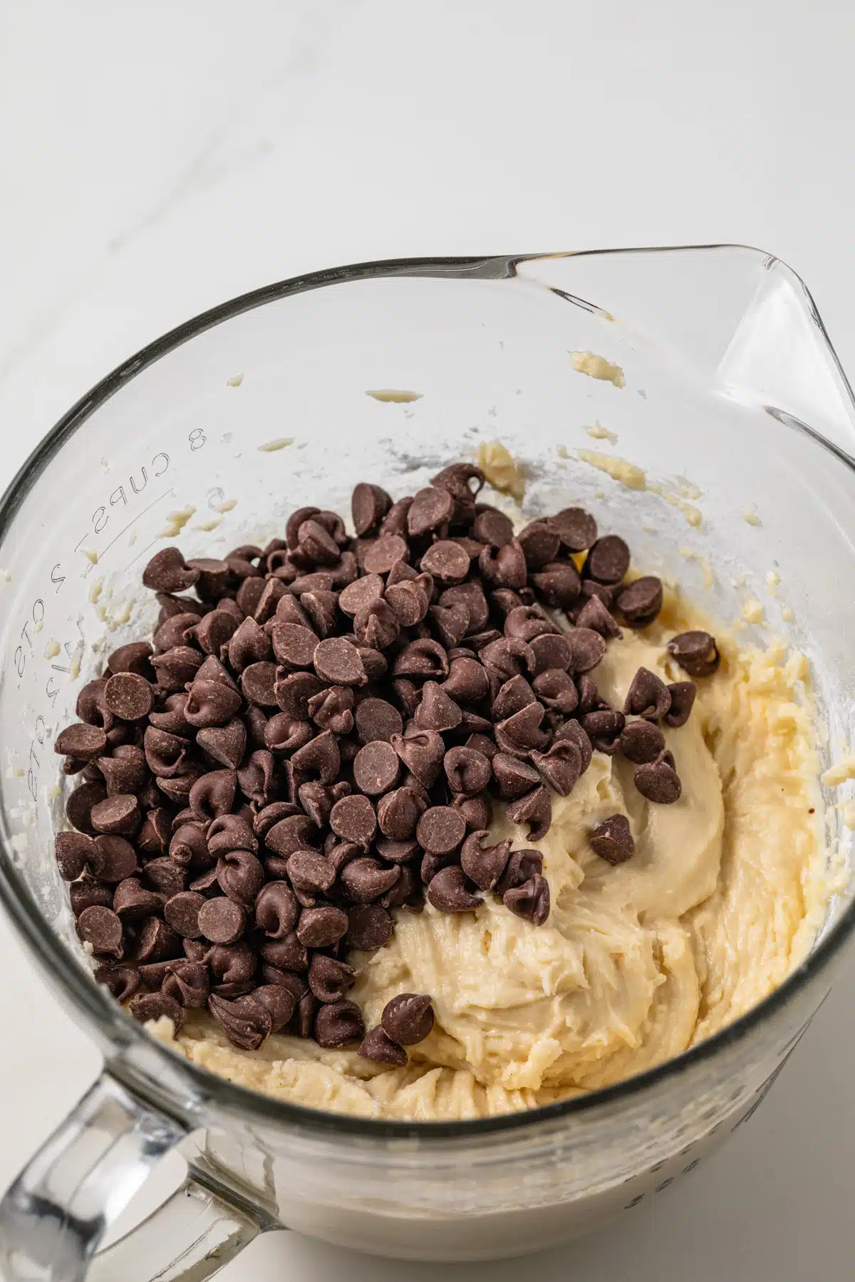 Coffee cake batter with chocolate chips in a glass bowl.