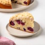 Slice of berry crumb cake on plate.