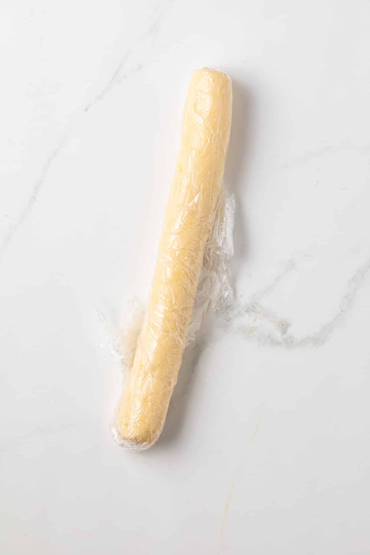 Cookie dough rolled into a log in plastic wrap.