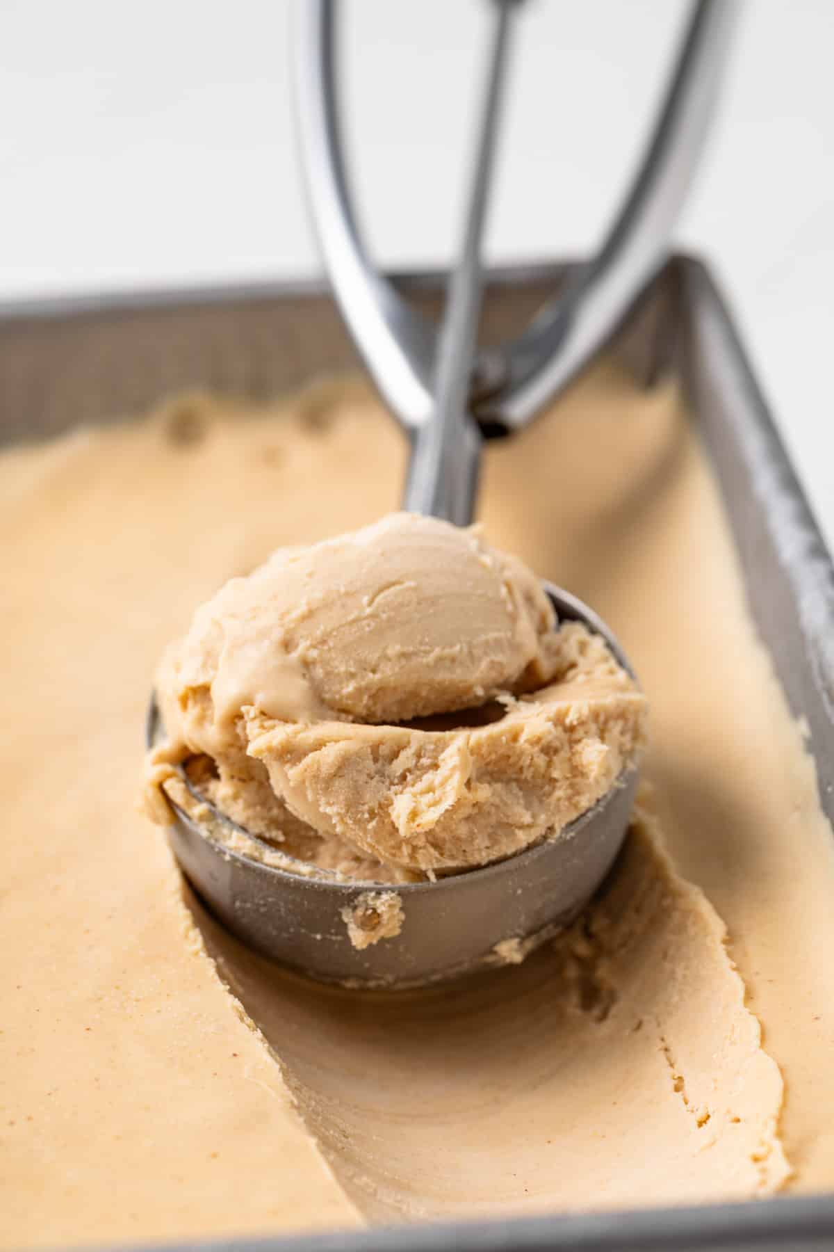 Side view of a scoop with peanut butter ice cream.