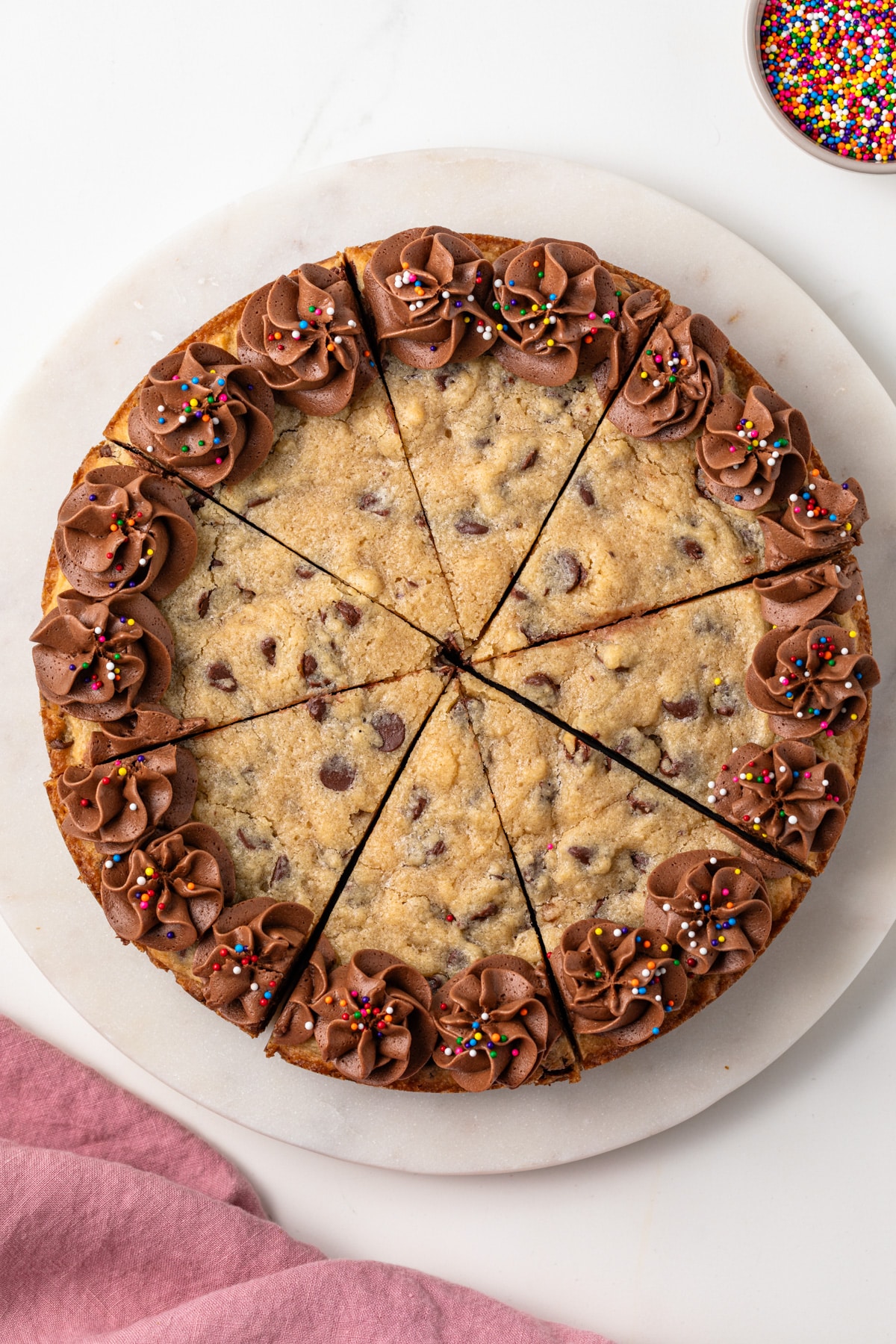 Chocolate chip cookie cake cut into slices.