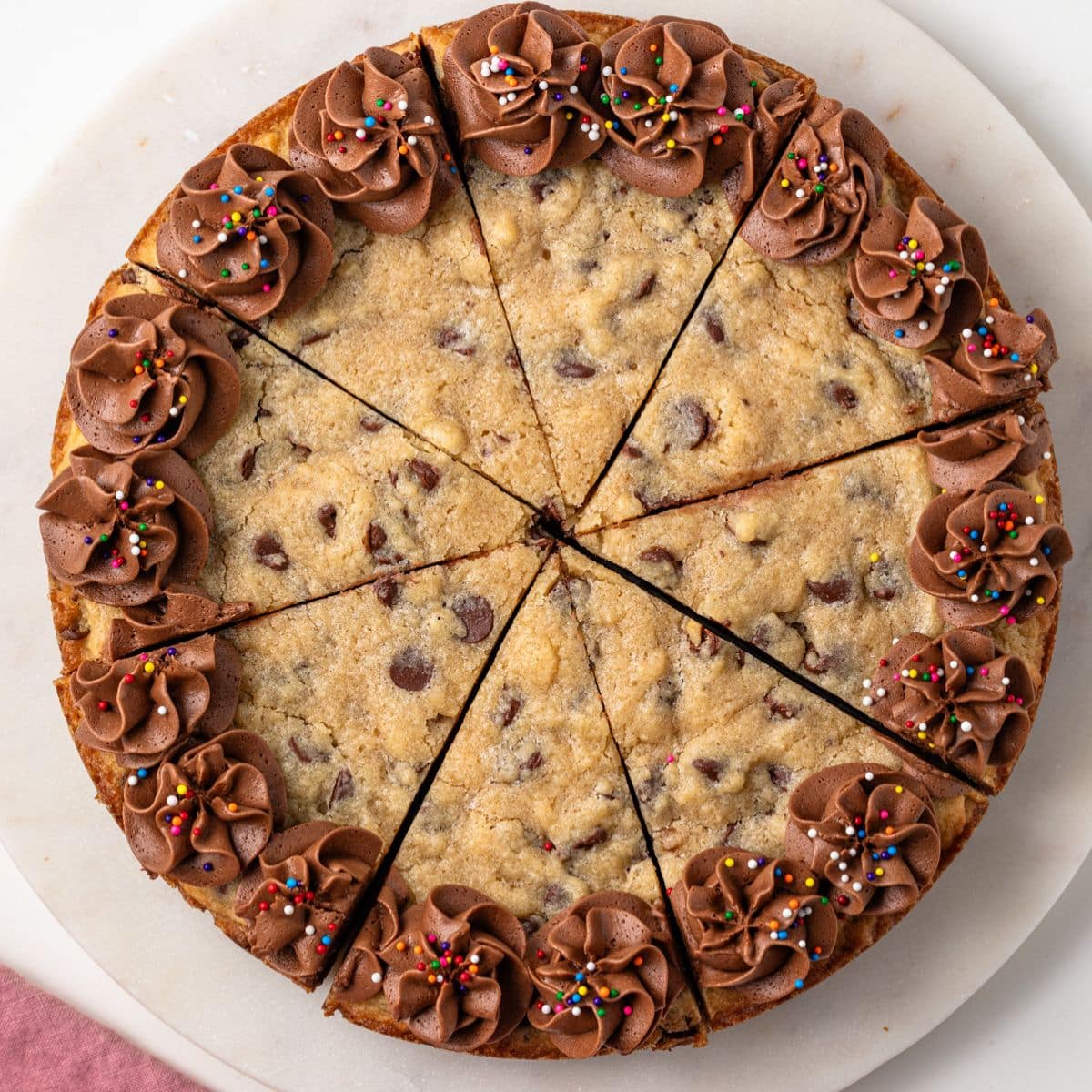 Chocolate chip cookie cake cut into slices.