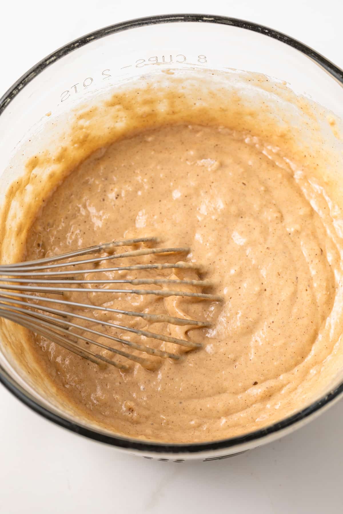 Apple cider donut batter in glass bowl.