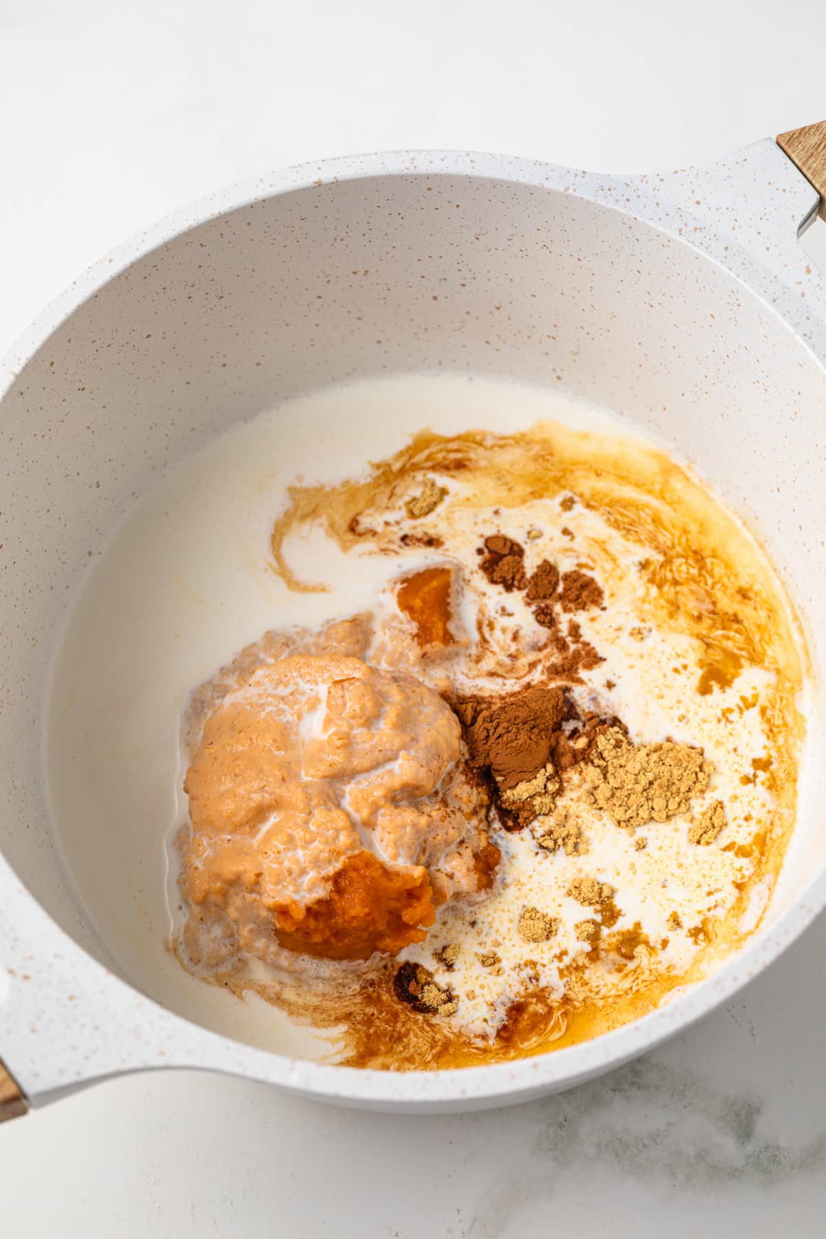 Pumpkin puree with heavy cream and spices in saucepan.