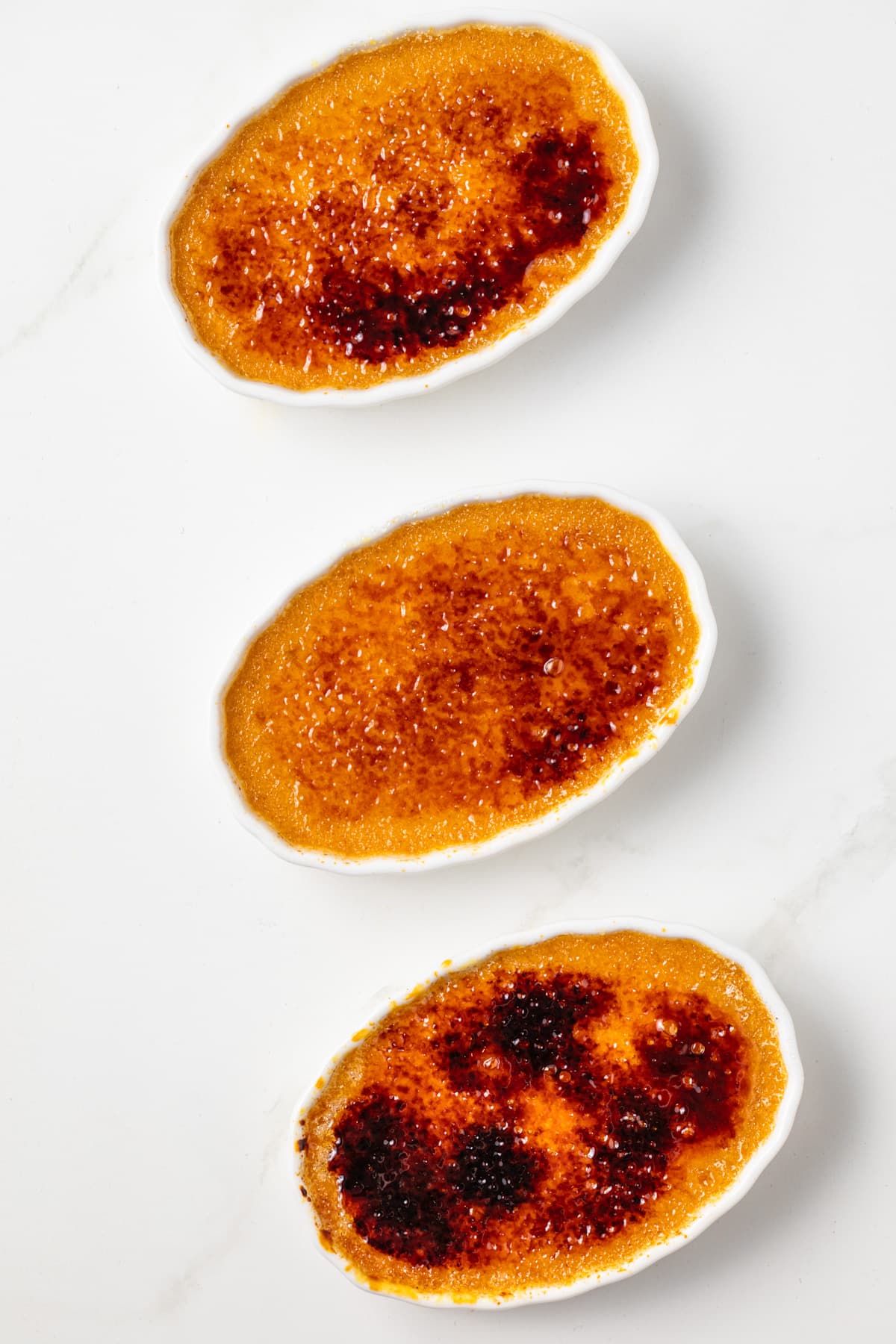 Overhead of pumpkin creme brulee in three ramekins.