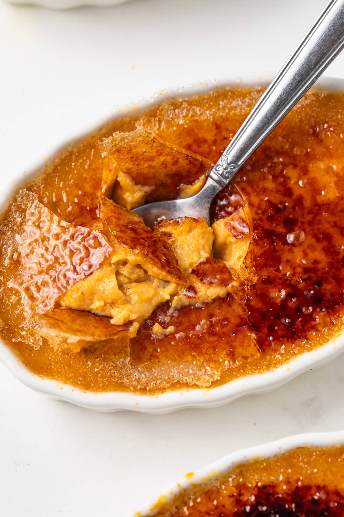Spoon scooping out pumpkin creme brulee.