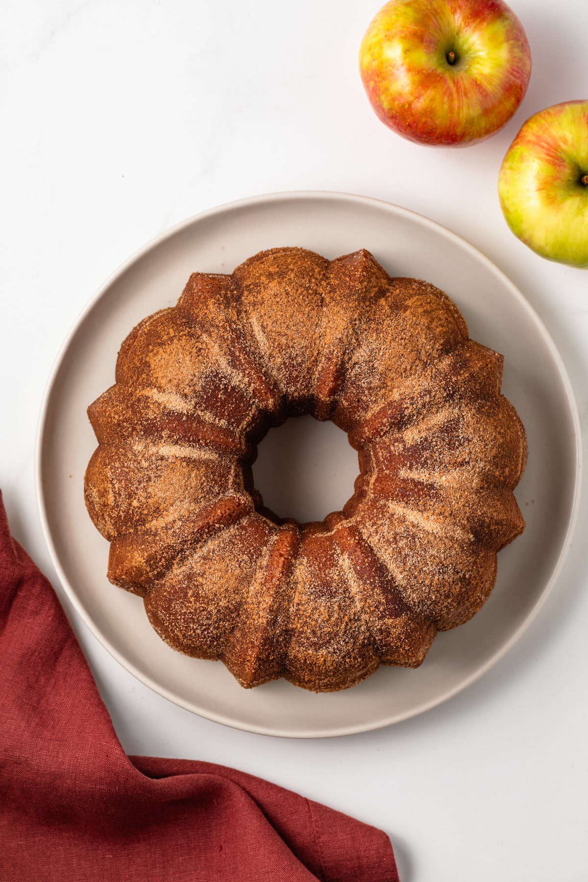 Overhead view of apple cider donut cake on a white plate.
