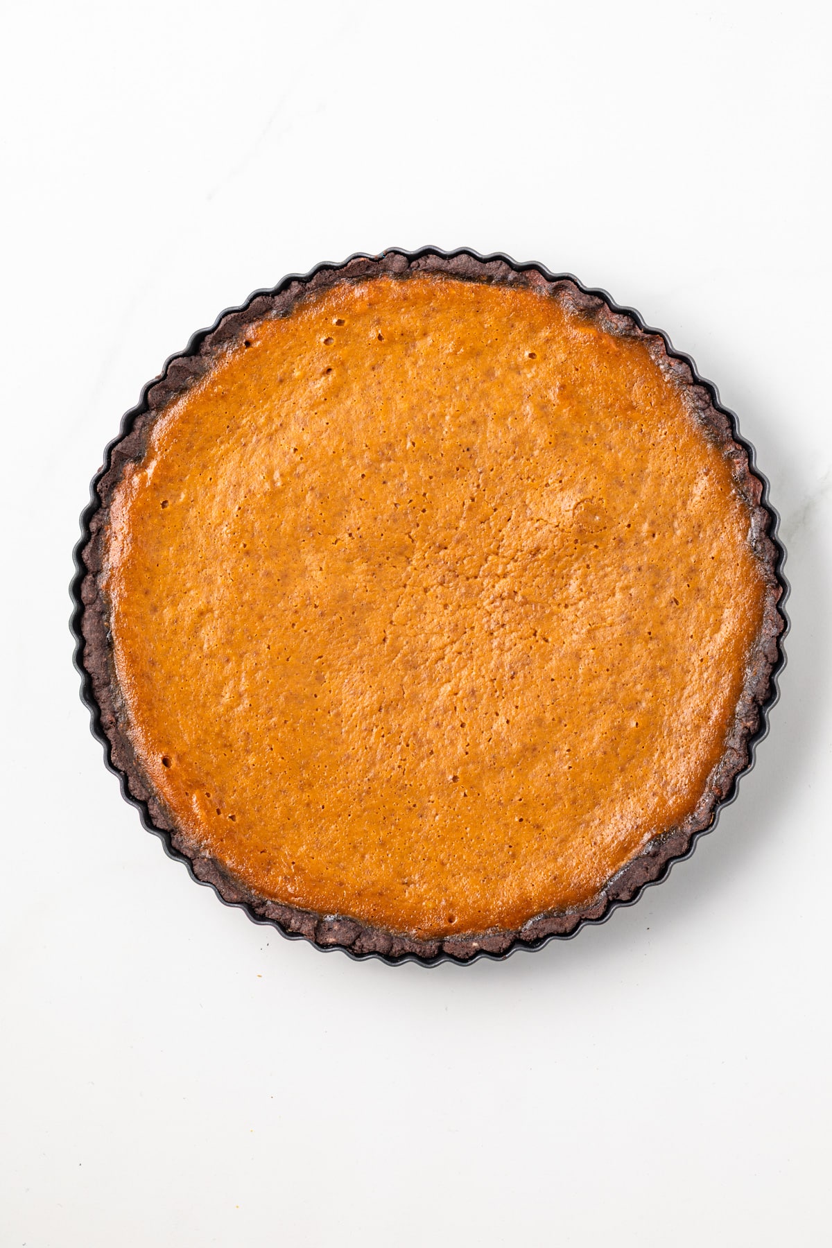 Chocolate pumpkin tart in tart pan.