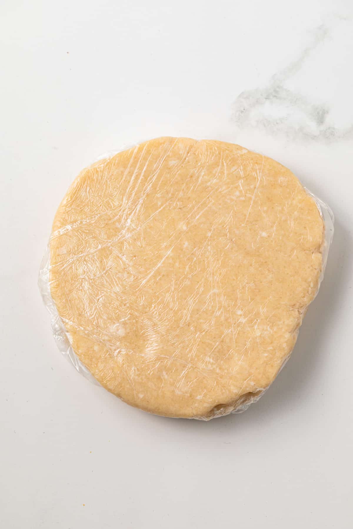 Pie dough wrapped in plastic wrap.