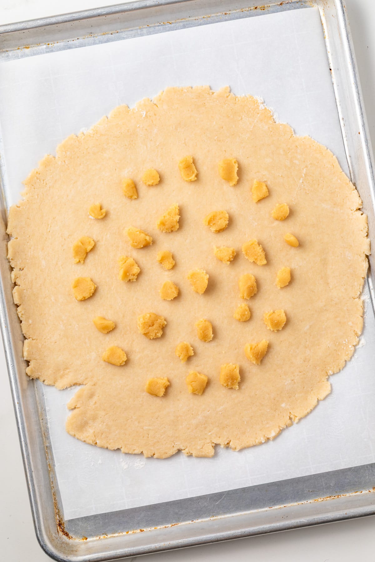 Rolled pie dough dotted with almond paste.