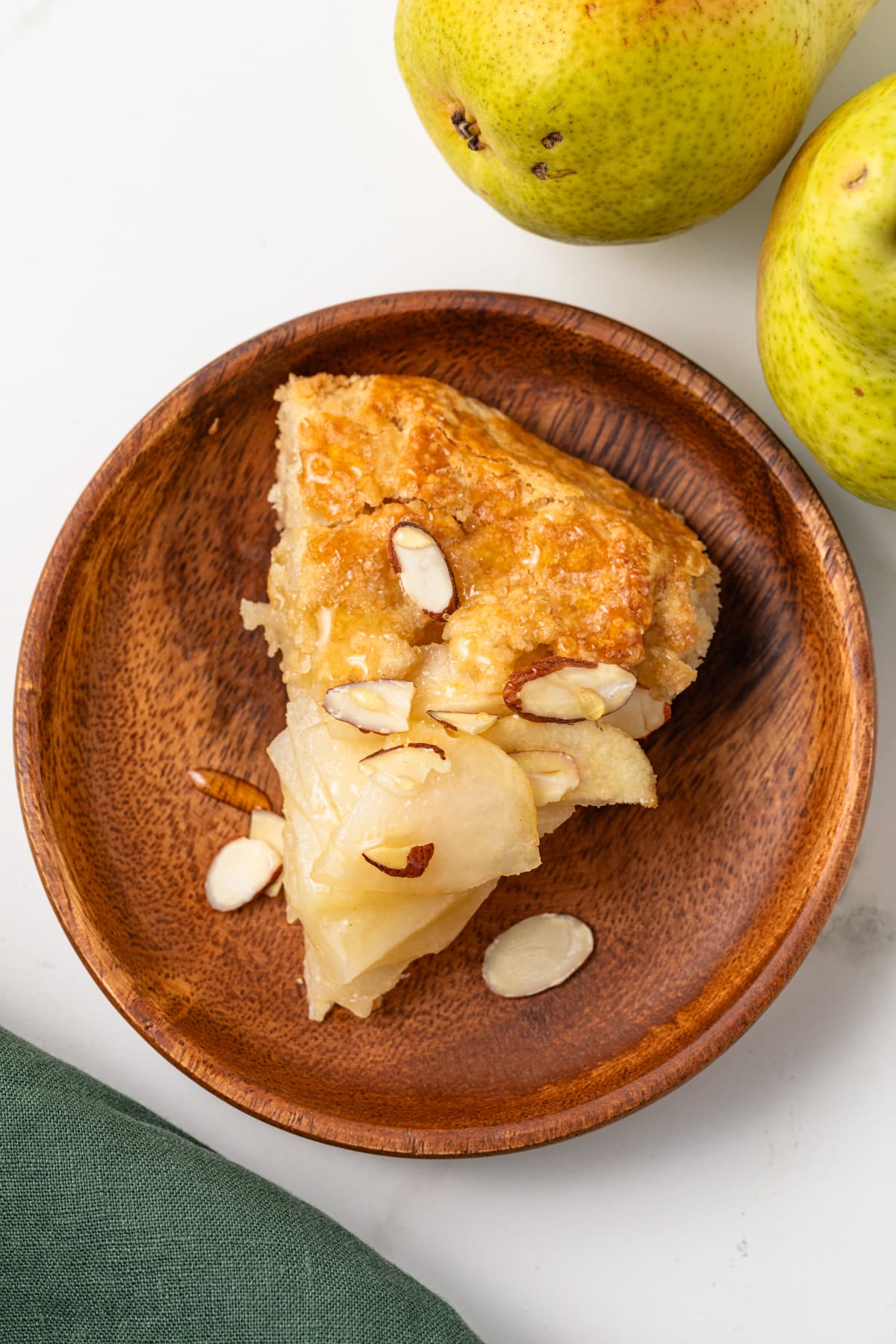 Slice of pear almond crostata on a plate.