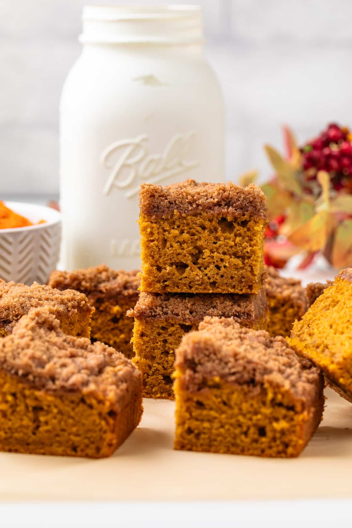 Pumpkin coffee cake squares stacked on one another.