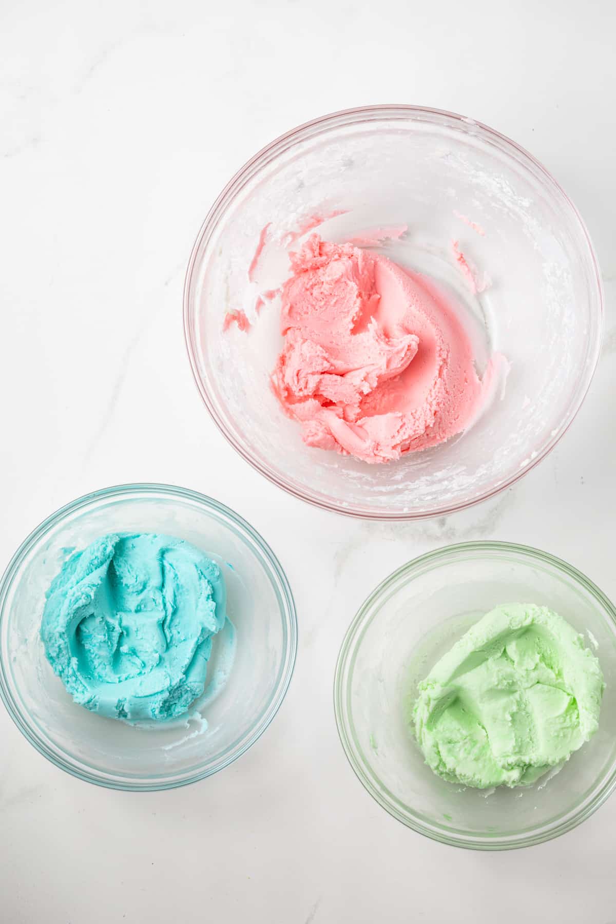 Cream cheese mint dough colored in separate bowls.